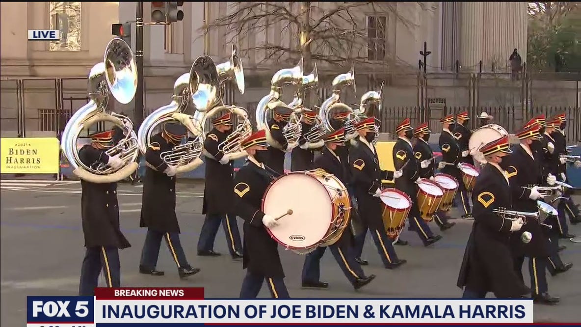 An array of performers escort President Joe Biden following his inauguration
